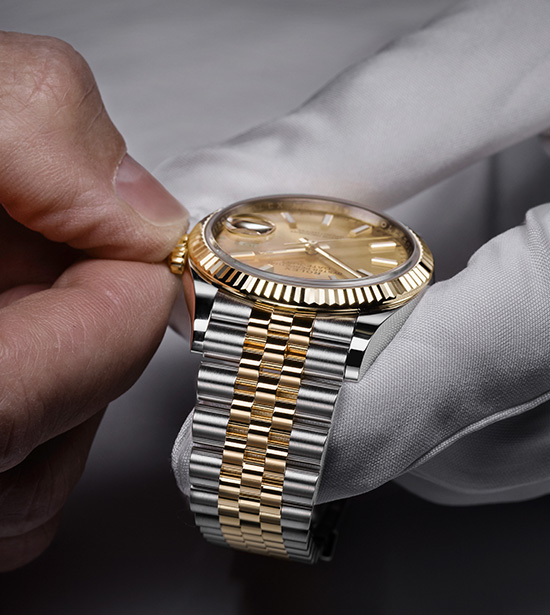 Händer som utför service av en Rolex-klocka